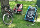 Thule Chariot CX 2 - przyczepka rowerowa dla 2 dzieci, a obok Nordic Cab - także dla dwójki dzieci.