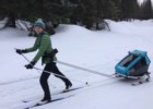 Zadowolona mama na nartach biegowych z dziećmi 